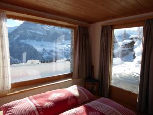 a bedroom with a window with a view of a snow covered mountain at Dado Casanova in Cumbels