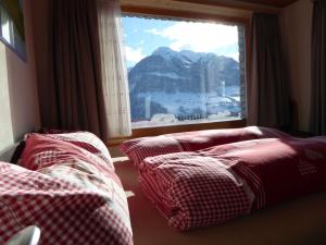 a room with two beds and a window with a mountain view at Dado Casanova in Cumbels