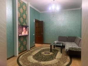 Armon Apart Hotel في خوجاند: غرفة معيشة مع أريكة وطاولة