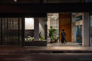 a person walking outside of a building at night at Beanstalk Bangkok in Bangkok