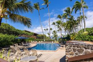 a swimming pool with chairs and palm trees at Napili Shores A106 Studio Condo condo in Kahana