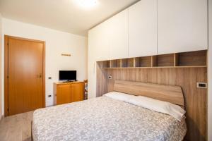 a bedroom with a large bed with a wooden headboard at Casa Penasa appartamento 2 in Commezzadura