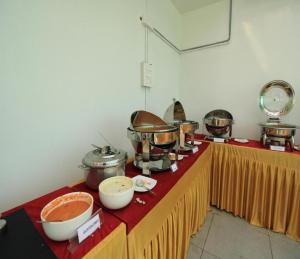 a kitchen with many pots and pans on a table at Orange Orchid 6BHK Private Pool Villa in Marakkānam