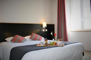 a hotel room with a bed with a tray of food on it at Domaine Agerria in Mauléon-Licharre