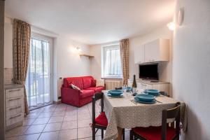 a living room with a table and a red chair at Casa Penasa appartamento 2 in Commezzadura