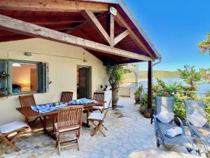 a patio with a table and chairs and a roof at Apraos Beachfront House by DadoVillas in Apraos