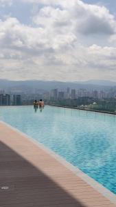 two people sitting in a swimming pool on top of a building at Mont Kiara 163 Mall (The Ooak) Private Room in Kuala Lumpur