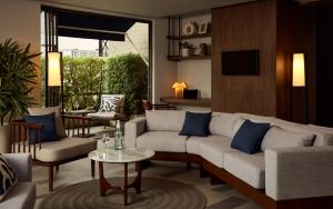 ein Wohnzimmer mit Sofa und Tisch in der Unterkunft Casa 17 Hotel Bangkok in Bangkok