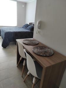 Habitación con escritorio, 2 sillas y 1 cama. en Departamento Estudio en pleno centro de Temuco en Temuco