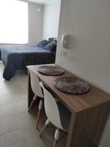 Habitación con escritorio, 2 sillas y 1 cama. en Departamento Estudio en pleno centro de Temuco, en Temuco