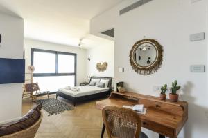 a living room with a couch and a table at Serene Studio Apt w Balcony Overlooking the Sea by Sea N' Rent in Tel Aviv