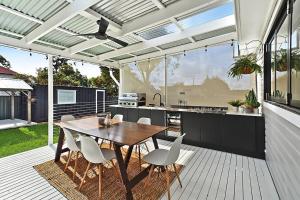 a patio with a table and chairs and a kitchen at Hunter Edge House in Cessnock
