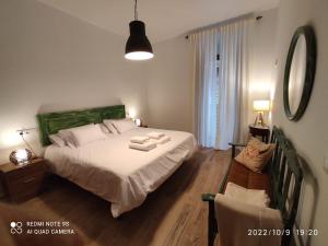 a bedroom with a large white bed and a chair at ENTRETORRES Apartamento Turístico in Olivenza