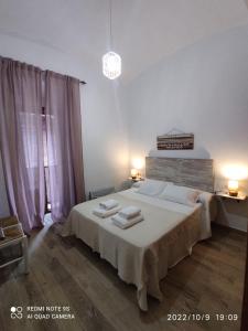 a bedroom with a large bed with two towels on it at ENTRETORRES Apartamento Turístico in Olivenza