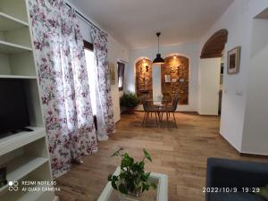 a living room with a dining room table and curtains at ENTRETORRES Apartamento Turístico in Olivenza