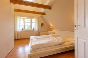 - un lit blanc dans une chambre avec fenêtre dans l'établissement Künstlerhaus Rosenthal 02, à Ahrenshoop