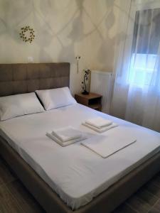 - un lit avec 2 serviettes blanches dans l'établissement kynosargous square's apartment, à Athènes