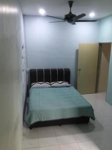a bedroom with a bed and a ceiling fan at Koolest homestays Meru in Ipoh +28 photos