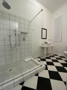 a bathroom with a shower and a black and white checkered floor at Back Home Bed and Breakfast in Graaff-Reinet