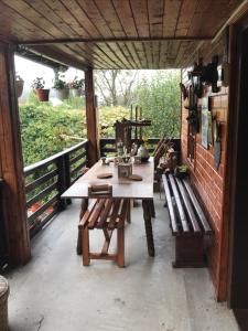 een houten tafel en banken op een patio bij Cabana Trei Brazi Dambovita in Bezdead