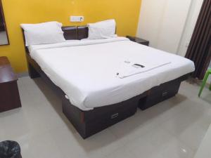 バンガロールにあるHotel Amster Innの白いマットレスが備わる客室の大型ベッド1台分です。