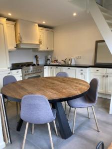 cocina con mesa de madera y sillas azules en Guesthouse Salty Life near the beach en Noordwijk aan Zee