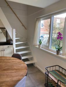 escalera en una cocina con mesa y ventana en Guesthouse Salty Life near the beach en Noordwijk aan Zee