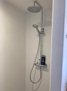 een douche met een douchekop in de badkamer bij Guesthouse Salty Life near the beach in Noordwijk aan Zee
