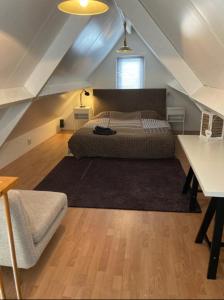 1 dormitorio en el ático con 1 cama y 1 mesa en Guesthouse Salty Life near the beach en Noordwijk aan Zee