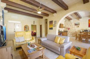 a living room with a couch and a table at Narcisa Holiday Home in Nadur