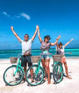 a family on the beach with their bikes at Moodhu Surf House in Himmafushi