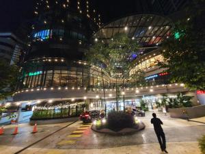 a man standing in front of a building at night at Mont Kiara 163 Mall (The Ooak) Private Room in Kuala Lumpur