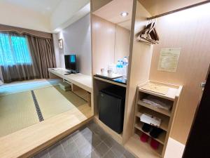 Cette petite chambre comprend un bureau et un ordinateur. dans l'établissement Hoya Hot Springs Resort & Spa, à Wenquan