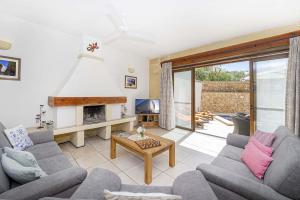 a living room with two couches and a fireplace at Razzett Luna Holiday Home in Xagħra