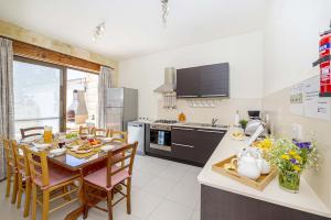 a kitchen and dining room with a table and chairs at Razzett Luna Holiday Home in Xagħra