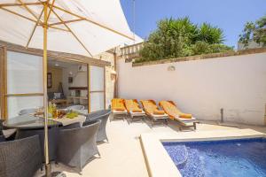 a patio with a table and chairs and a swimming pool at Razzett Luna Holiday Home in Xagħra