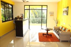sala de estar con paredes amarillas, sofá y mesa en SAHAY VILLA RESORT 