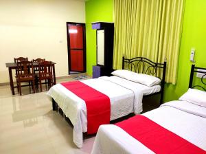 2 camas en una habitación con verde y rojo en SAHAY VILLA RESORT 