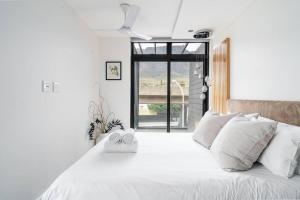 a bedroom with a white bed with two towels on it at 16 on Sloane in Cape Town