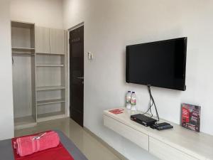 a living room with a flat screen tv on a wall at RedDoorz near RSUD Margono Purwokerto 3 in Purwokerto