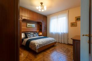 a bedroom with a large bed and a window at Villa Mara - Aosta - 200 mq - WiFi - Jacuzzi - Parcheggio - Giardino in Aosta