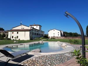 einen Pool in einem Hof mit zwei weißen Gebäuden in der Unterkunft Agriturismo Casalbergo in Isola della Scala