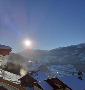 een uitzicht op een besneeuwde vallei met de zon op de achtergrond bij Apart Bergauf in Rohrberg