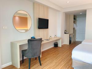 a hotel room with a desk and a bed and a mirror at Miloft Sathorn Hotel in Bangkok +64 photos