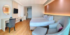a hotel room with a bed and a couch at Miloft Sathorn Hotel in Bangkok