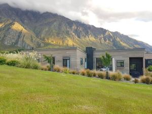 a house with a mountain in the background at Beautiful Lake and Alpine Views - Queenstown in Queenstown