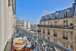 uma varanda com um cesto de comida numa saliência em Maison Barbès em Paris