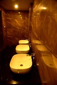 a bathroom with two toilets and a sink at Vyshak International in Payyannūr