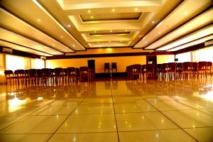 an empty hall with chairs and tables in it at Vyshak International in Payyannūr