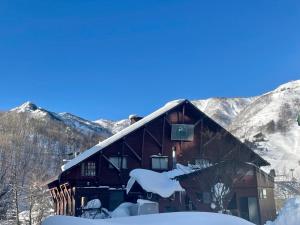 湯沢町にあるHeidi Guest House の山々を背景に雪に覆われた家